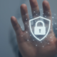 Main protégeant un cadenas numérique, symbole de cybersécurité et de protection des données